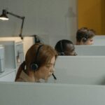 A Woman with Headset Inside a Gray Cubicle